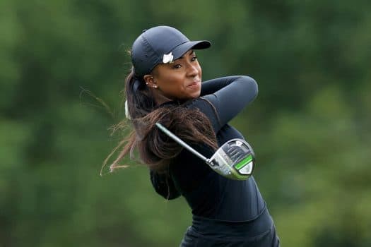 A beginner taking their first confident swing with a mentor by their side